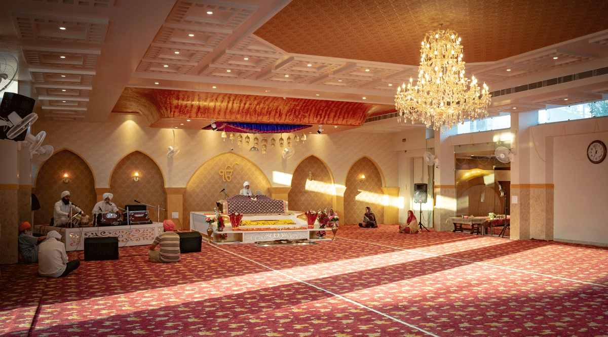 Gurudwara main hall with red floral carpet installation - religious venue carpet by MR Enterprises Panipat India